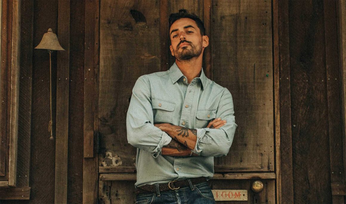 Male model arms crossed wearing chambray shirt.