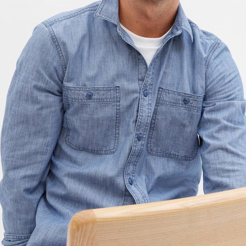 Male model sitting wearing Gap chambray shirt